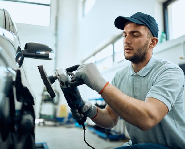 An auto detailer working on a vehicle in your auto detailing career