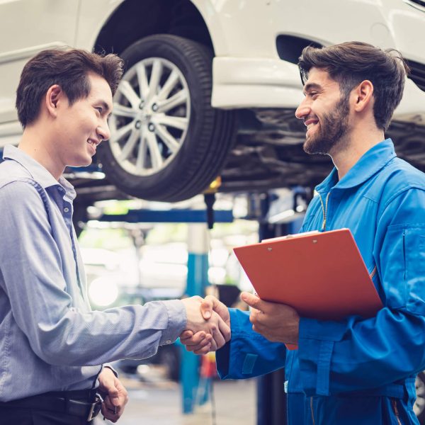 Service advisor greeting a customer at a dealership after service advisor training.