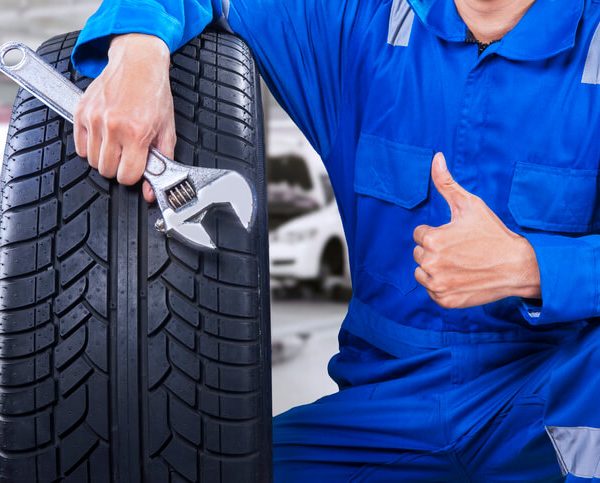 An auto parts specialist working on a tire in a warehouse after auto parts training.