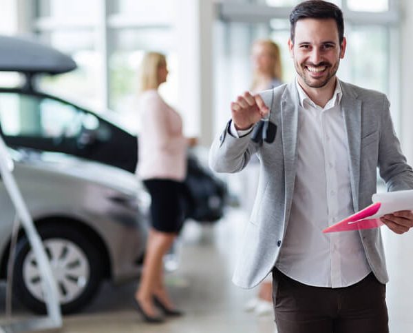 A car salesman at a dealership after completing his auto sales training
