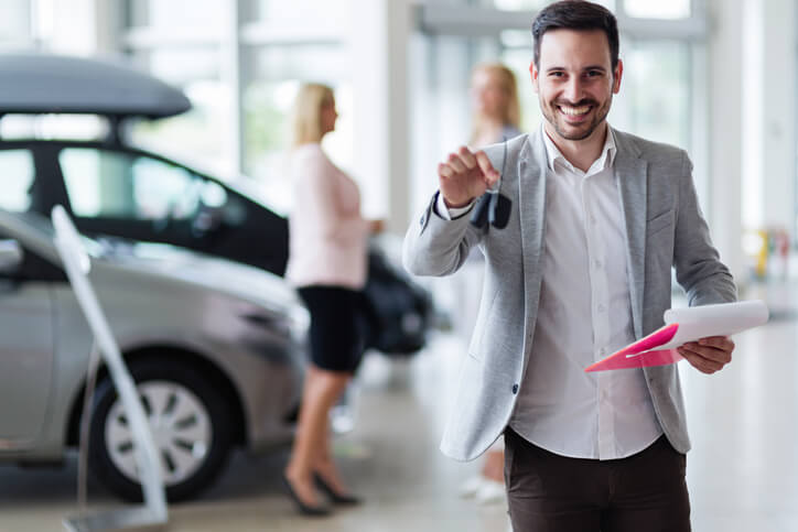 A car salesman at a dealership after completing his auto sales training