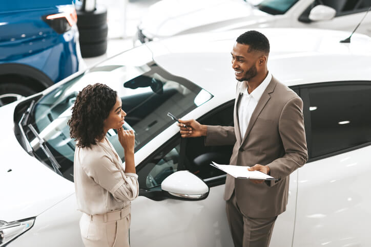 A male auto salesman communicating with a female customer after auto sales training