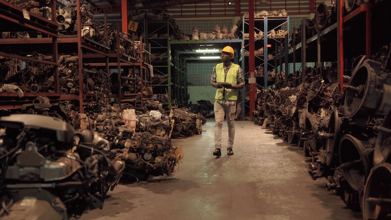 An auto parts training graduate in a warehouse