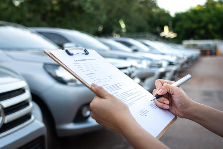 An auto sales training grad inspecting vehicles in a parking lot