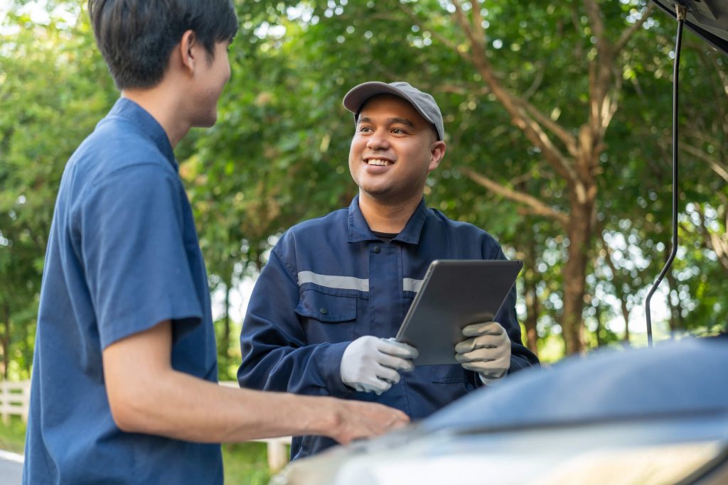 An auto parts clerk discussing with his smiling employer after his auto parts training