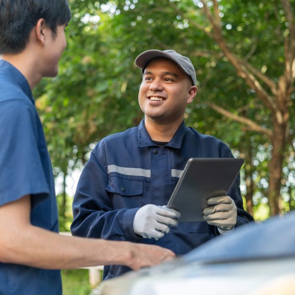 An auto parts clerk discussing with his smiling employer after his auto parts training