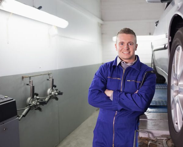 A confident auto mechanic at a garage