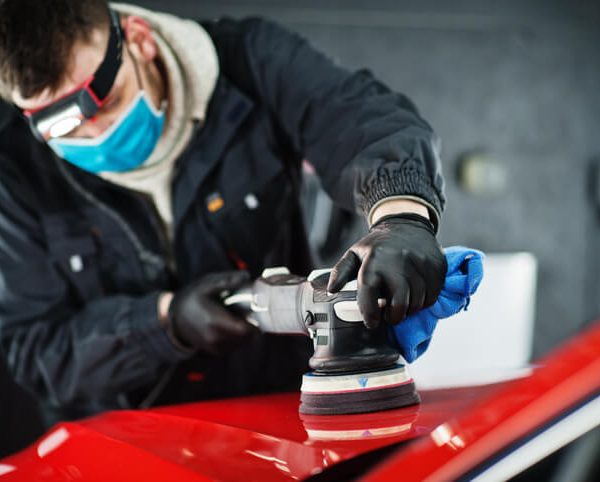 A male auto detailing professional working on a car