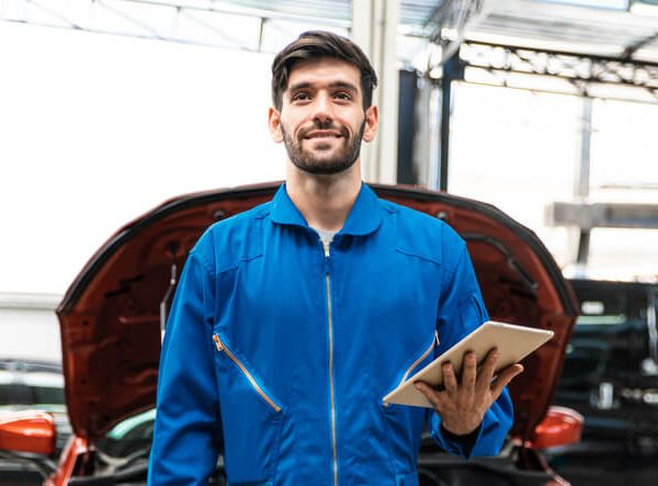A male auto mechanic at a repair shop after completing his auto mechanic training