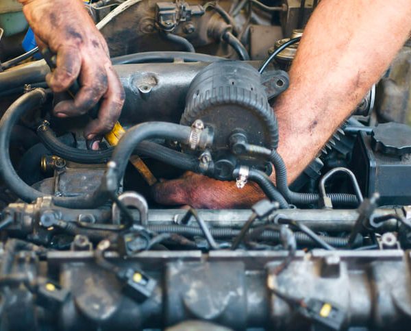 A male mechanic working on a diesel engine after completing his diesel mechanic training