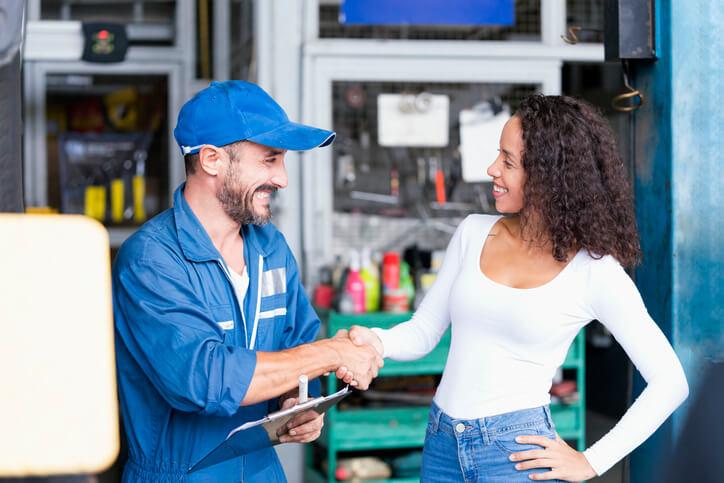 An auto mechanic school graduate interacting with a client