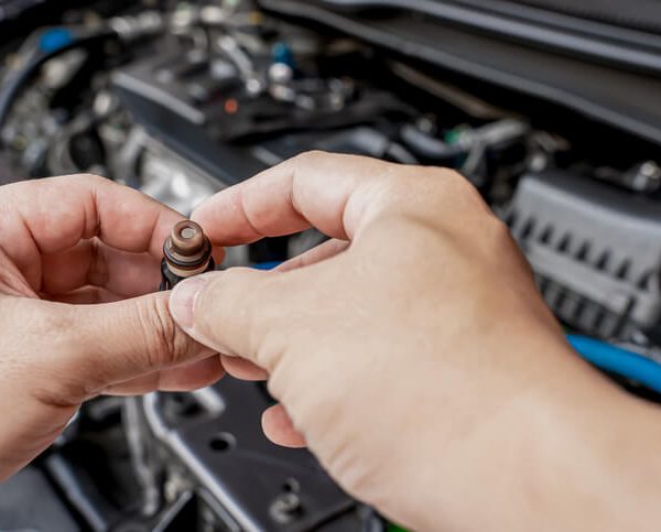 A CATI student inspecting a fuel injector in the automotive lab