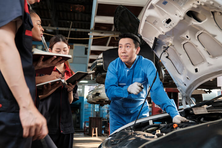 A group of automotive training students gaining hands-on learning knowledge of fuel systems at CATI