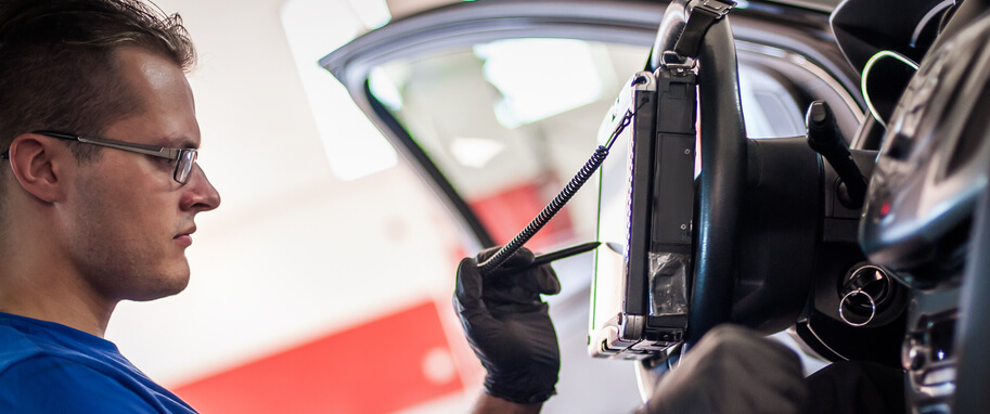 A focused male auto mechanic using diagnostic software during automotive training