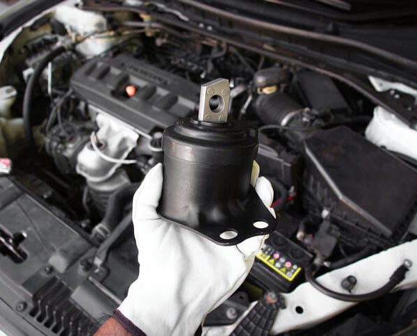A student in an automotive training class examining an engine mount