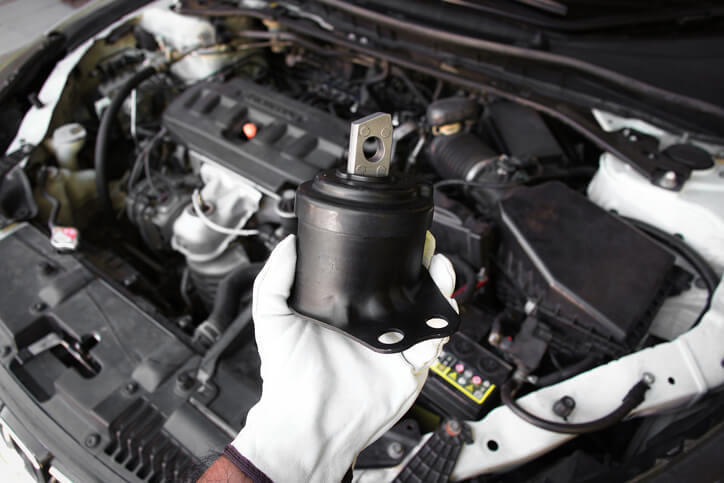 A student in an automotive training class examining an engine mount