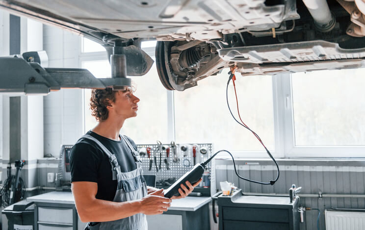 Automotive training student examining a vehicle