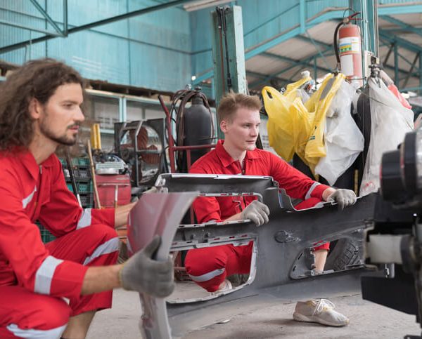 A student learning about vehicle subframes at an automotive school