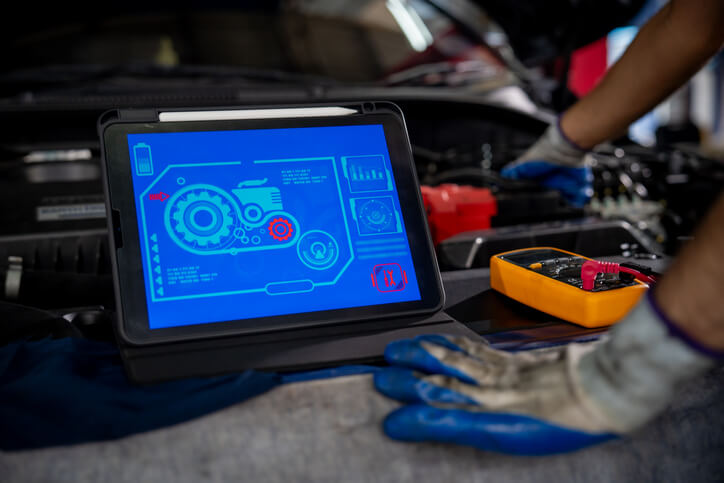 Auto technician diagnosing a powertrain vibration