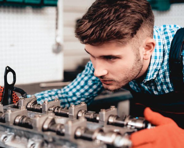 An automotive student examining a diesel engine in class