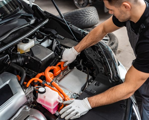 An automotive training graduate on a hydrogen fuel cell vehicle in a CATI shop