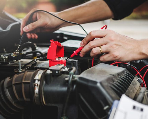 A student performing hands-on diagnostics during auto mechanic training in a fully equipped garage at CATI.