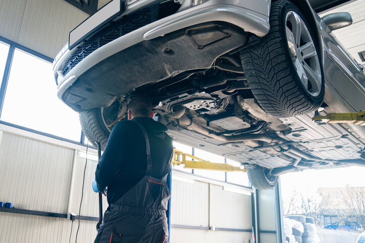 An instructor at the CATI school demonstrates safe lifting techniques during automotive training
