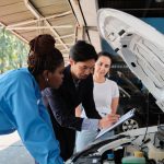 A pair of apprentice mechanics learning engine inspection during auto mechanic training at CATI.