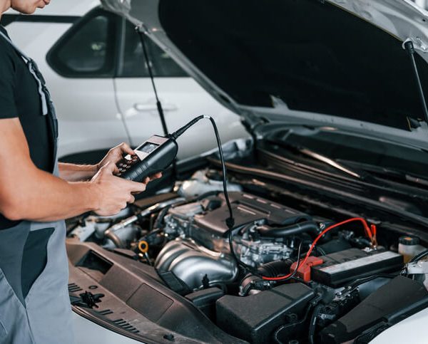 An auto mechanic student at CATI using a smart diagnostic scanner on a modern car