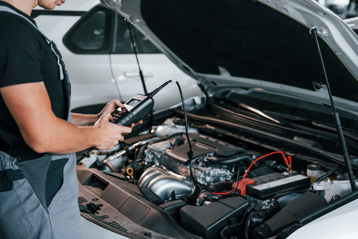 An auto mechanic student at CATI using a smart diagnostic scanner on a modern car