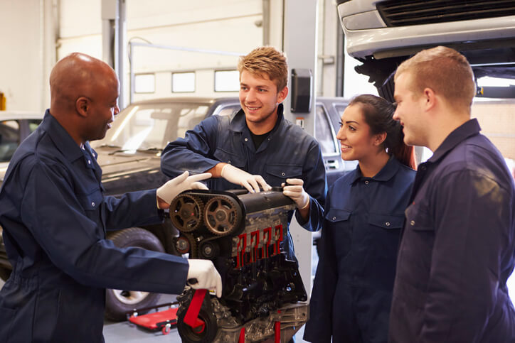 A CATI school student verifying his questions during hands-on auto mechanic training.