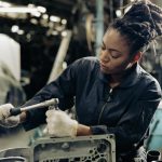 A student in auto mechanic training is tightening engine bolts during hands-on workshop practice