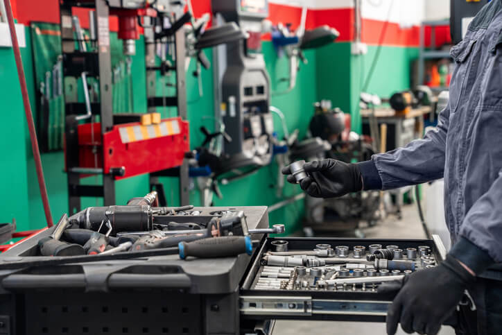 The hands of a CATI student adjusting tools during automotive training, emphasizing hands-on experience