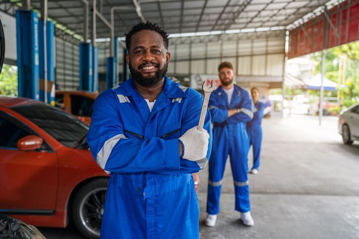 A cati school automotive graduate posing with a wrench in the workshop