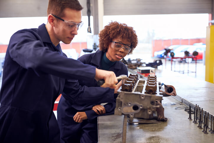 A student practicing automotive repair skills during early mechanic apprenticeship training