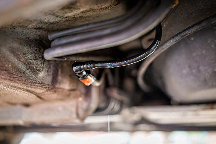 A close-up of coolant leaking from a radiator hose connection.