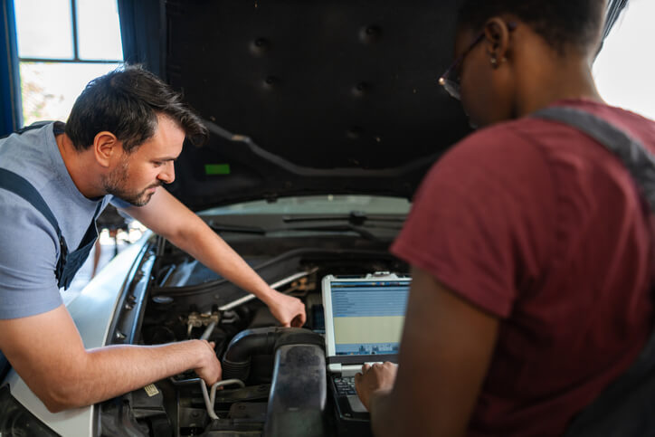 A student learning ignition diagnostics during an automotive training class
