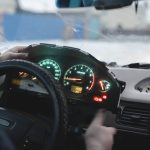A technician checking an electronic throttle light on a vehicle dashboard