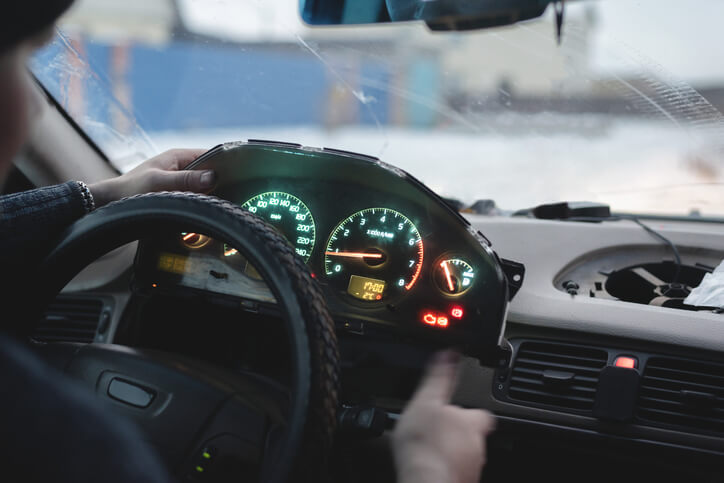 A technician checking an electronic throttle light on a vehicle dashboard