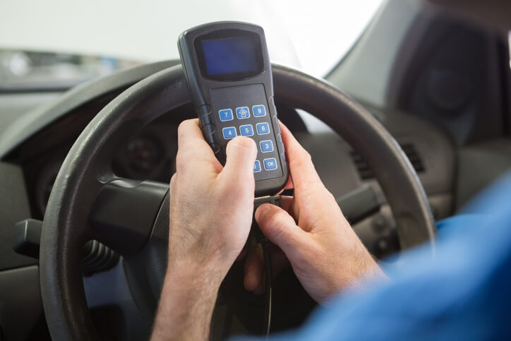 A mechanic using a scan tool to check electronic throttle control codes