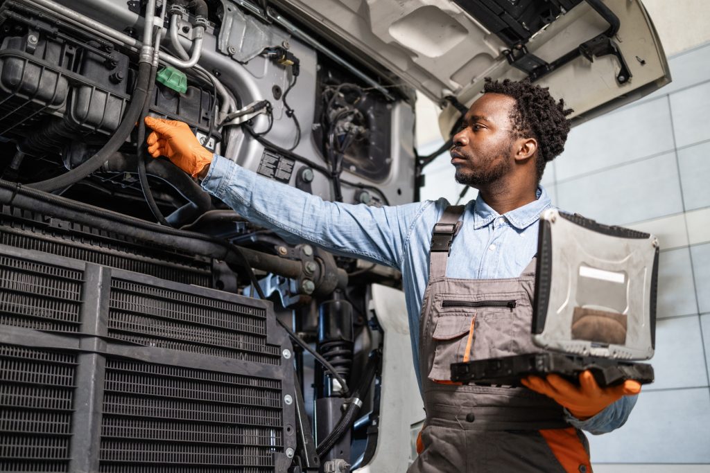 A fleet mechanic performing preventative maintenance on a commercial vehicle