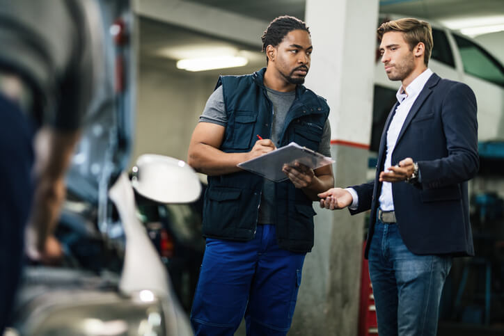 A customer meeting with a service advisor in an automotive repair facility