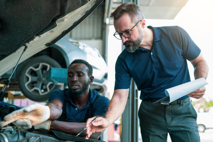 A service advisor reviewing repair recommendations with an automotive technician