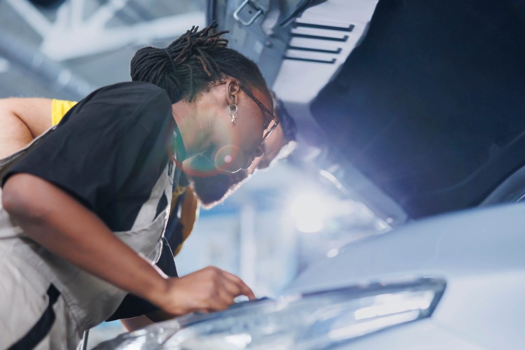 A student inspecting a vehicle as part of automotive technician training
