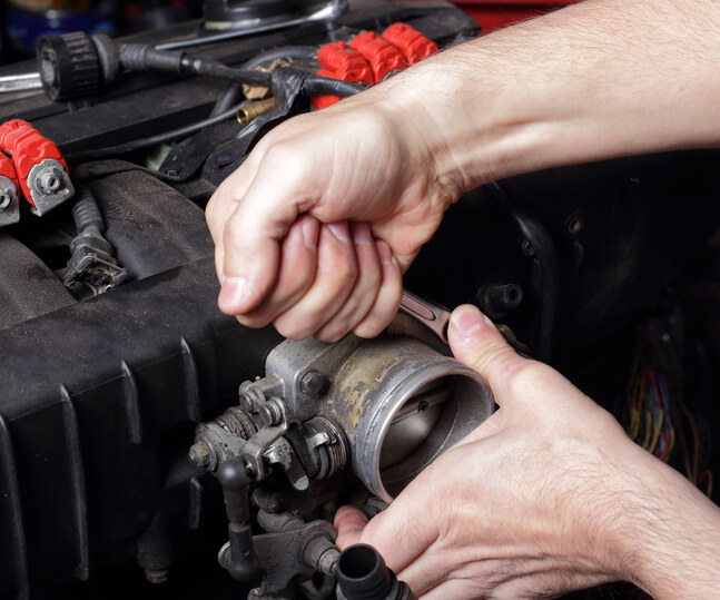 Student learning throttle body inspection in an automotive training lab