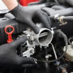 Automotive student inspecting a throttle body during engine diagnostics training