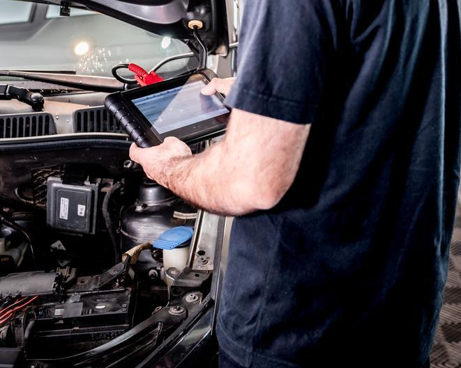 An automotive student using a scan tool to diagnose an EGR system fault