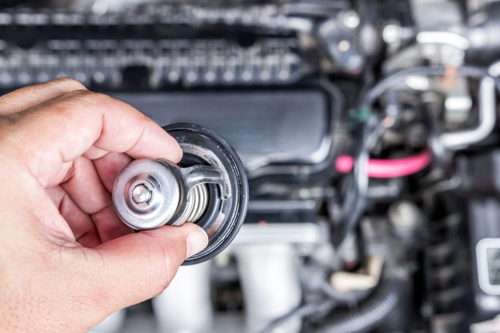 Technician investigating bad thermostat symptoms in a vehicle
