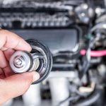 Technician investigating bad thermostat symptoms in a vehicle