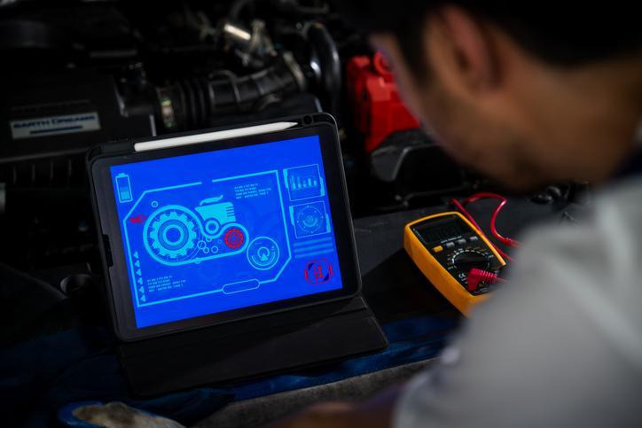 A student using a scan tool to diagnose engine stalling
